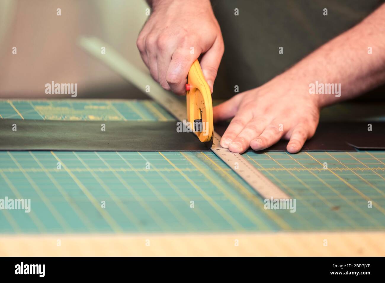 Cutting leather with a rotary cutter on a grided board Stock Photo Alamy