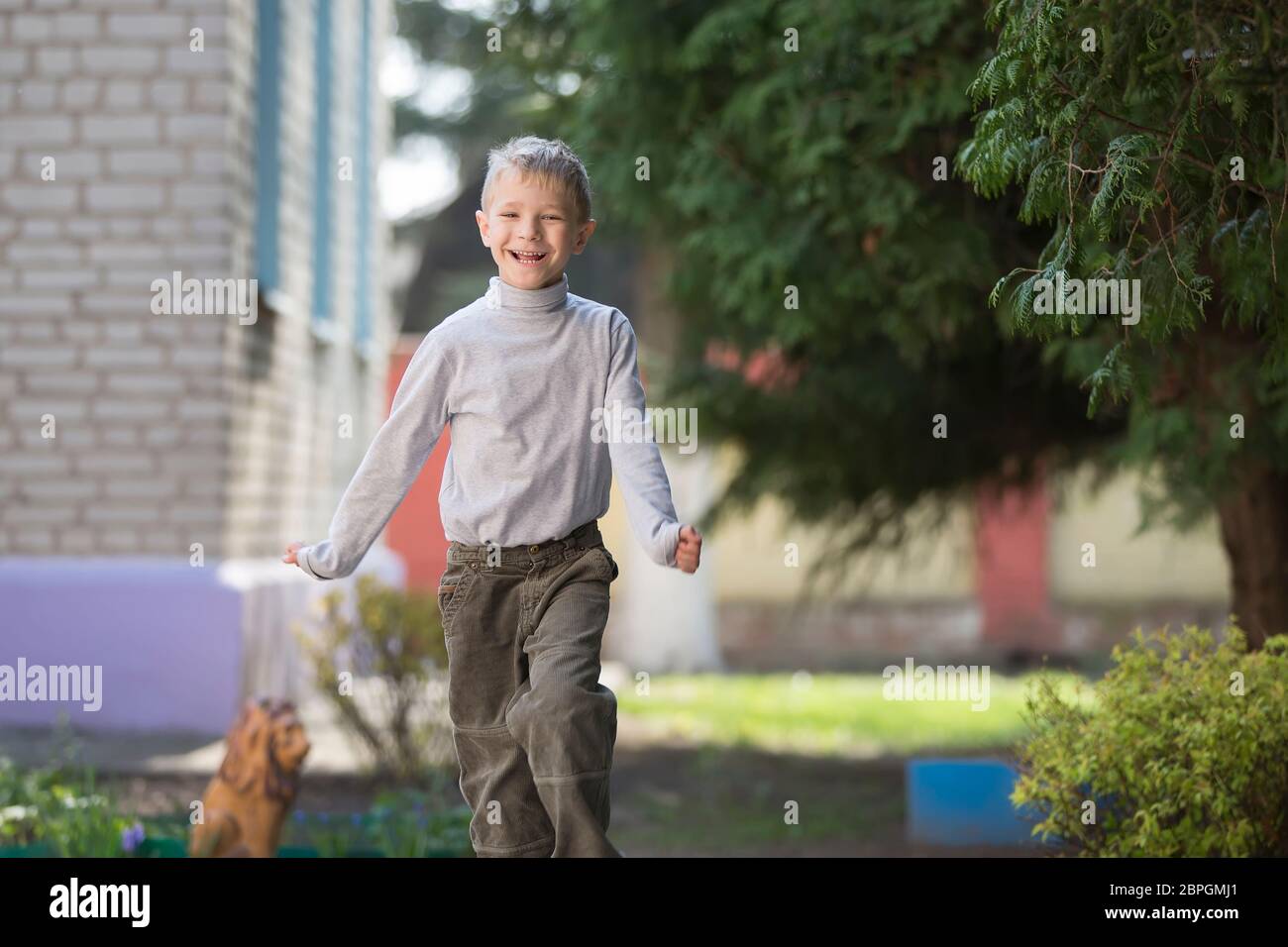 Belarus, the city of Goml, April 26, 2019. Photosession in kindergarten.Funny happy child is walking down the street. Six year old cheerful boy on a s Stock Photo
