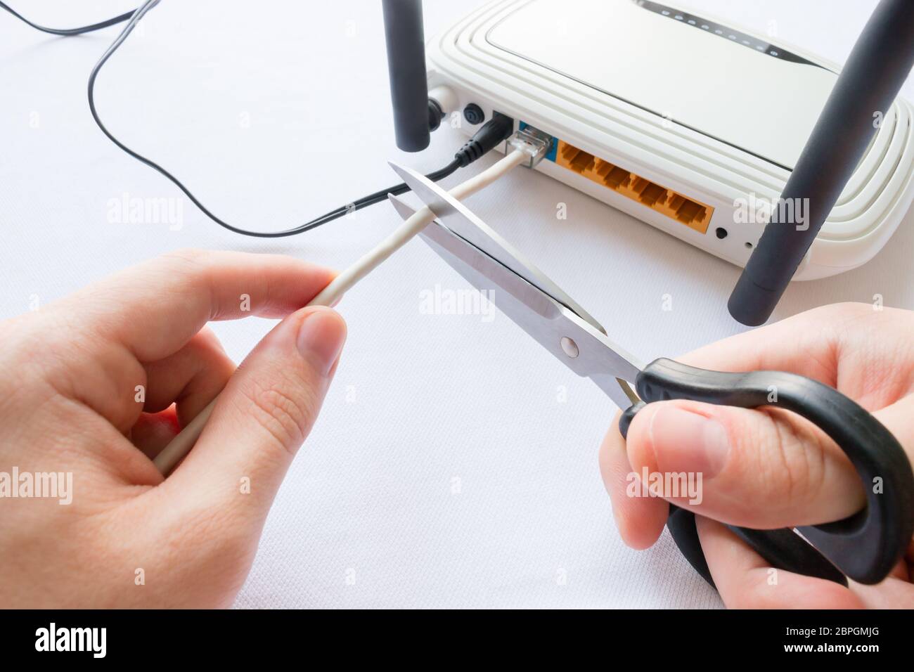 man cuts Internet cable connected to the router Stock Photo - Alamy