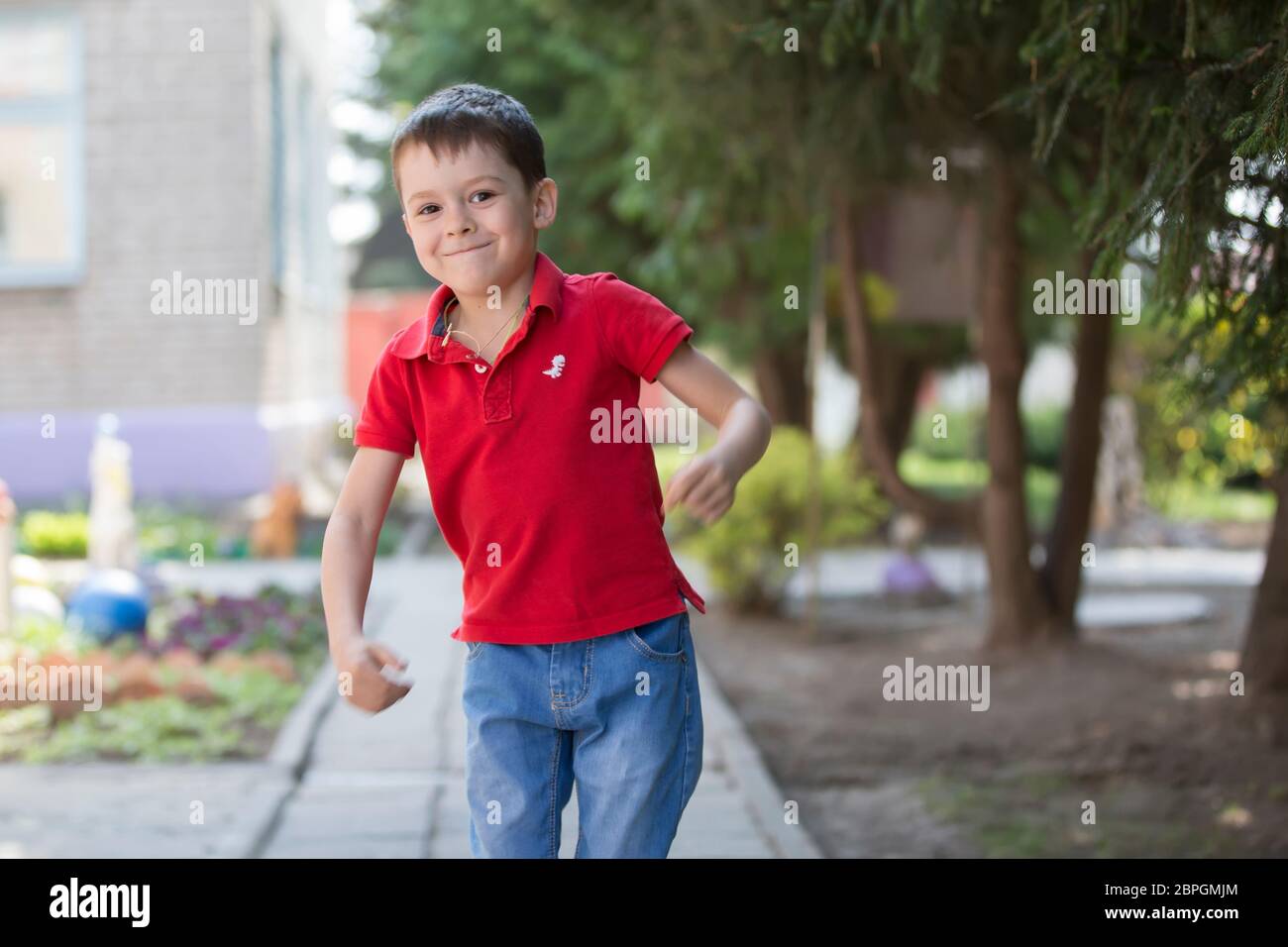 Belarus, the city of Goml, April 26, 2019.  Photosession in kindergarten.Funny preschooler child is walking down the street. Six year old cheerful boy Stock Photo