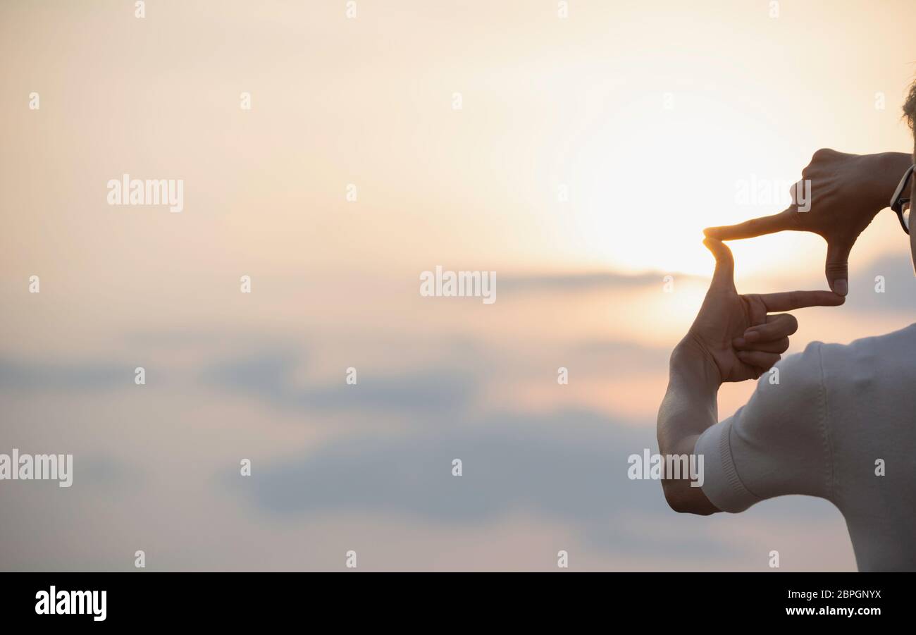 Hands making frame with sunset. Close up of woman hands making frame ...