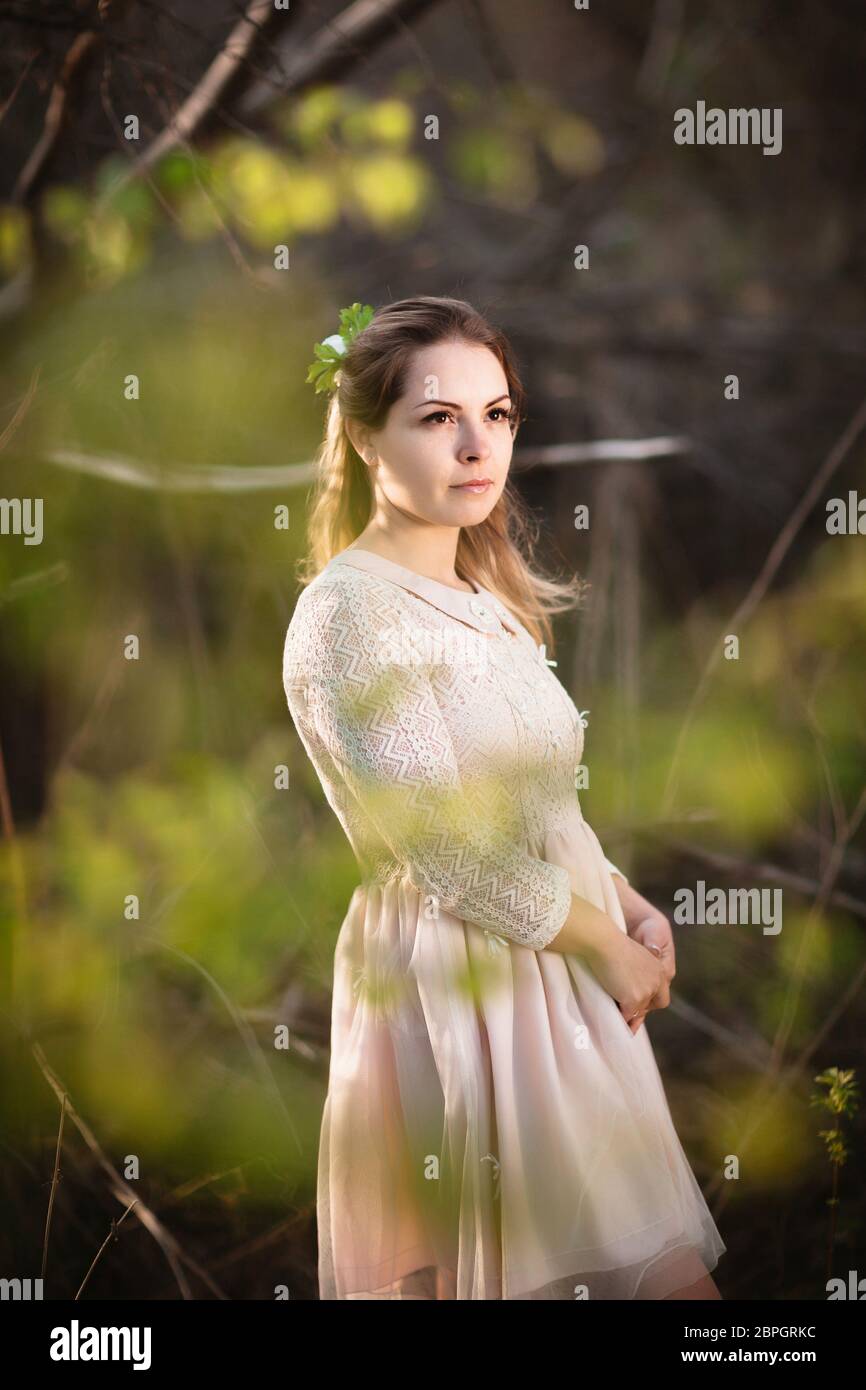 Beautiful girl standing in a field on a sunset background Stock Photo ...