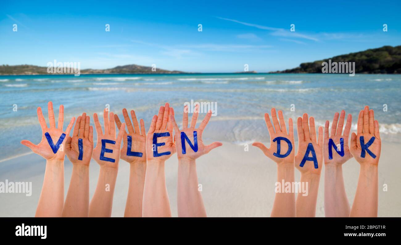 Many Hands Building German Word Vielen Dank Means Thank You. Beautiful Beach, Ocean And Sea As Background Stock Photo