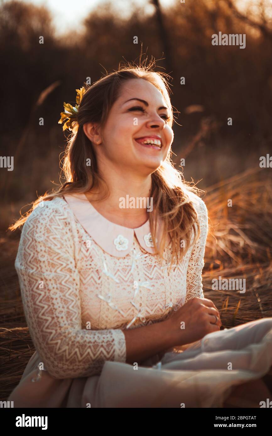 girl is sitting in the field on the sunset background Stock Photo - Alamy