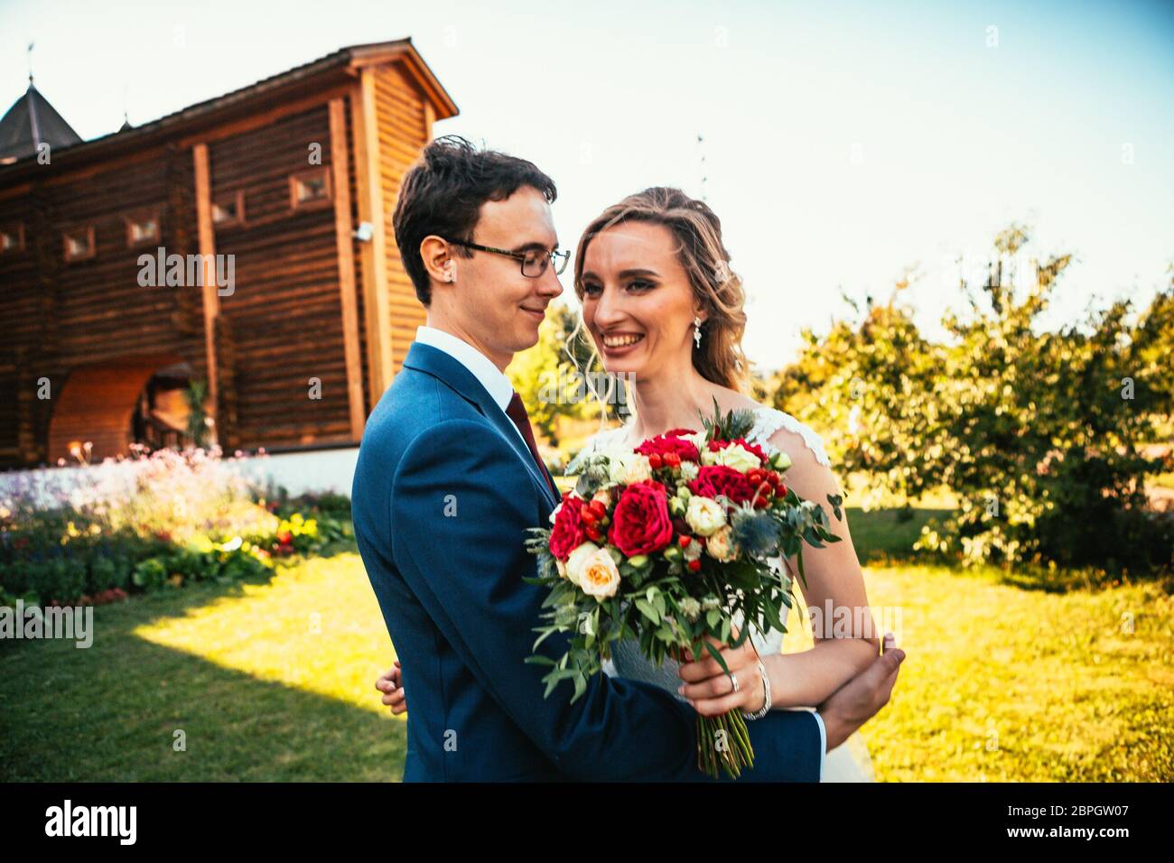 Walk young bride and groom on old house background Stock Photo - Alamy