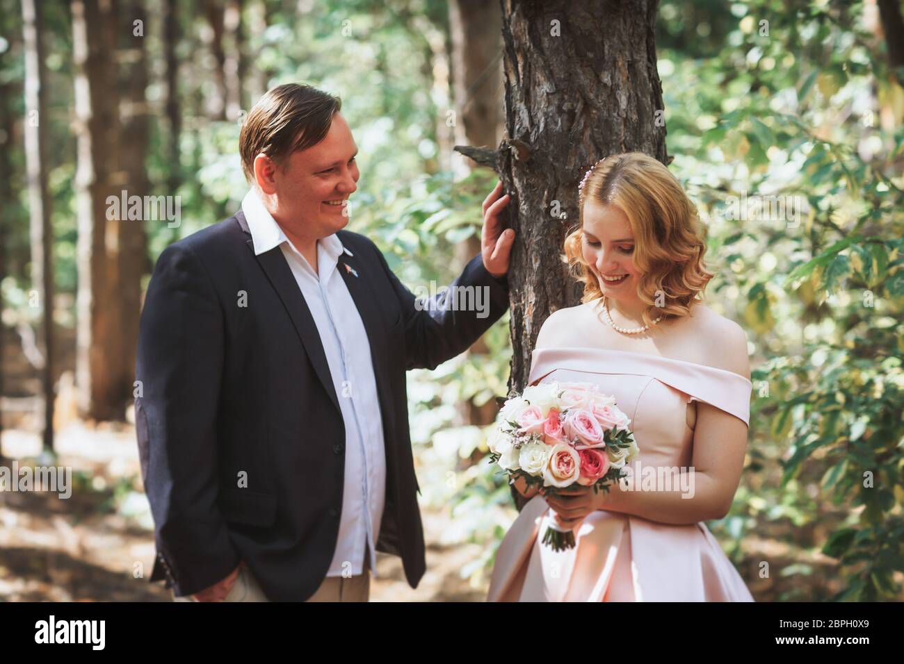 bride and groom kiss on the background of trees and forest Stock Photo ...