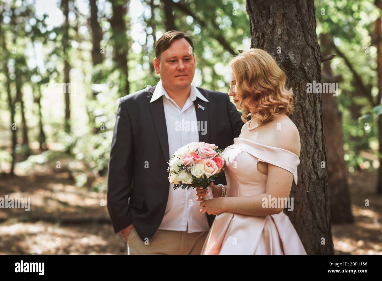 bride and groom kiss on the background of trees and forest Stock Photo ...