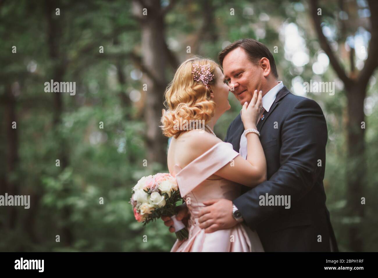 bride and groom kissing in the summer forest Stock Photo - Alamy