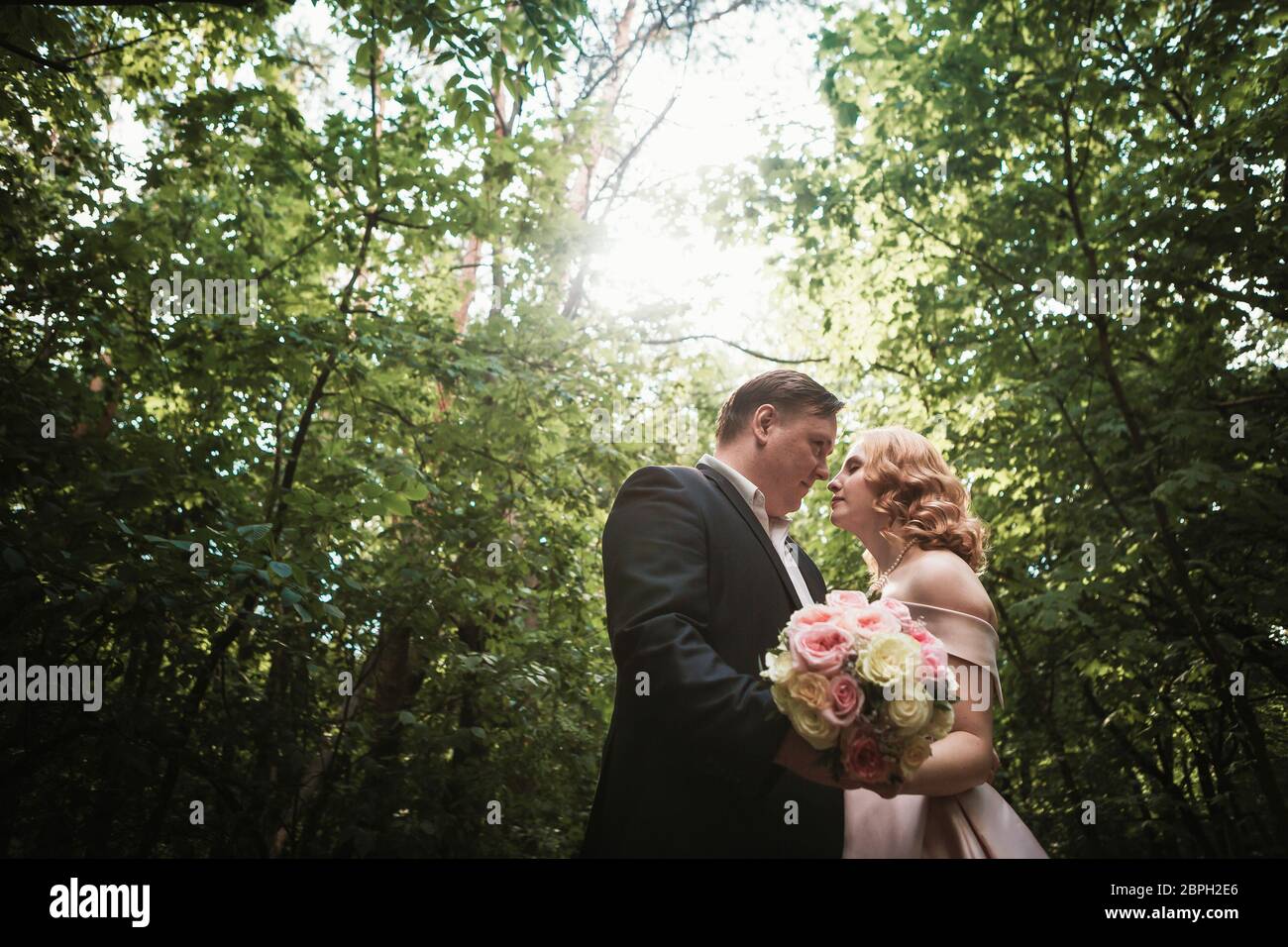 bride and groom dancing in the forest background and sunlight Stock ...