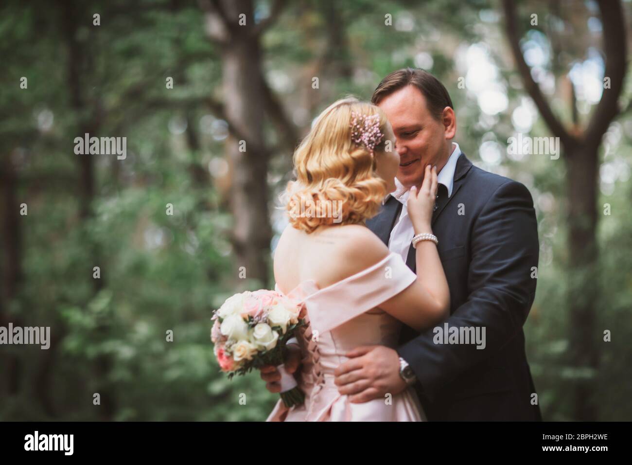bride and groom kissing in the summer forest Stock Photo - Alamy