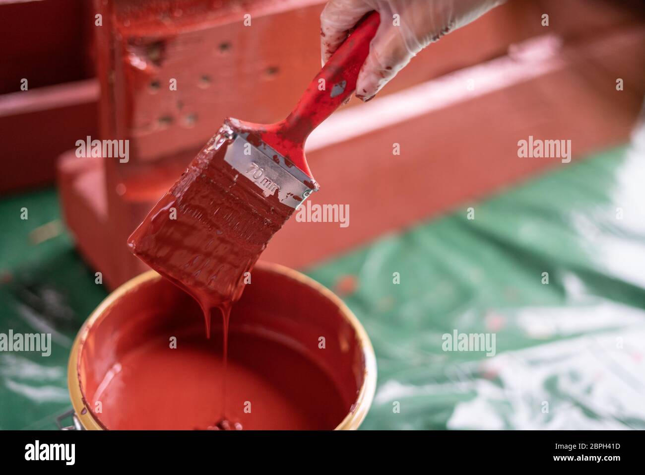 Painting red paint outdoors in summer Stock Photo