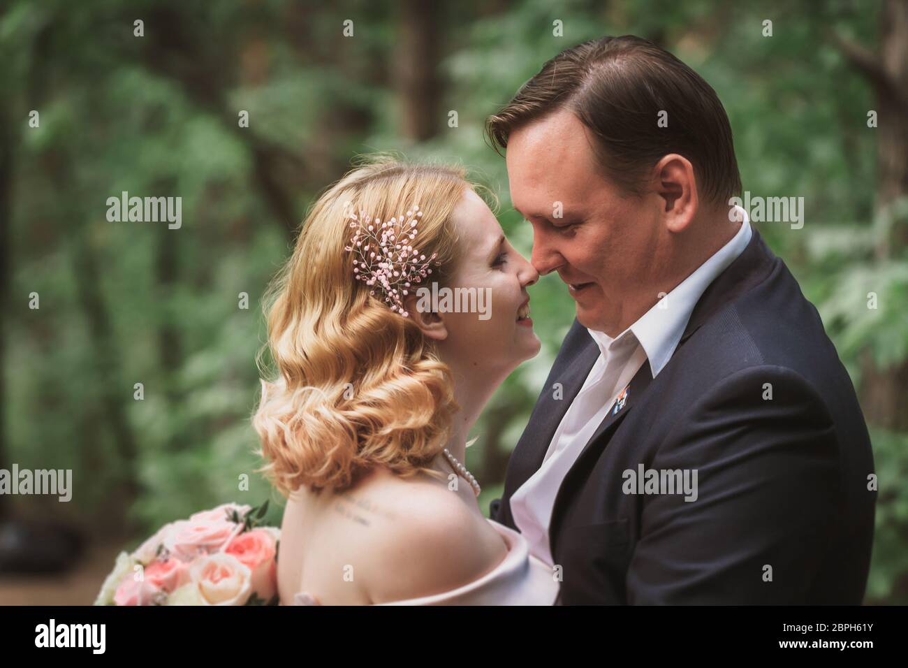 bride and groom kissing in the summer forest Stock Photo - Alamy