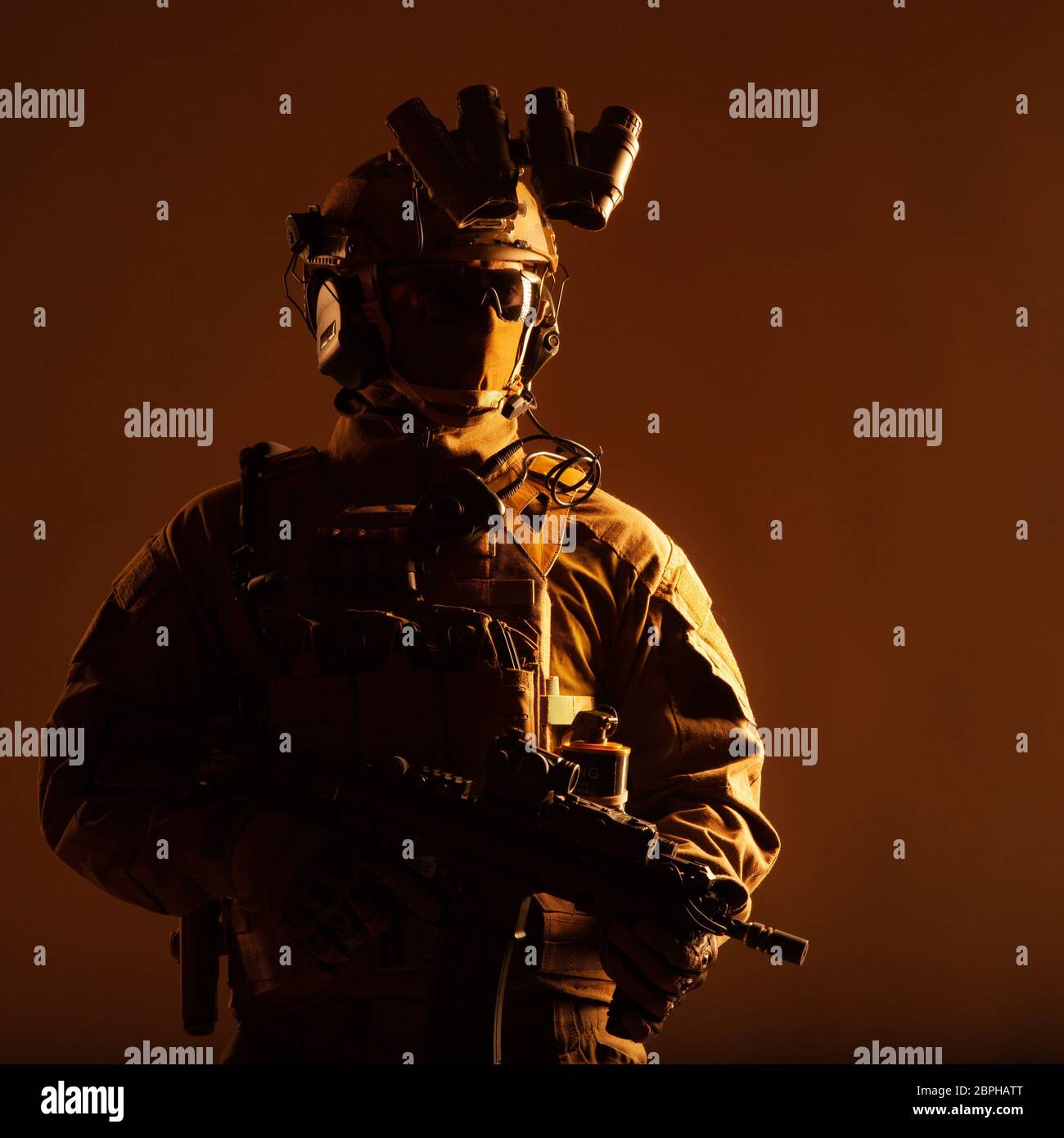Army elite forces member, modern infantryman with hidden face, in tactical ammunition, equipped radio headset, night vision device mounted on helmet, Stock Photo