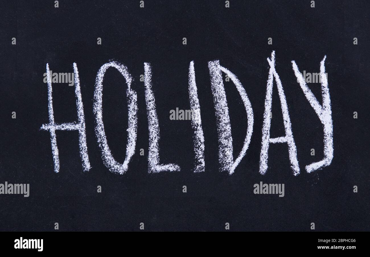 Blackboard with Holiday inscription on blackboard background Stock Photo