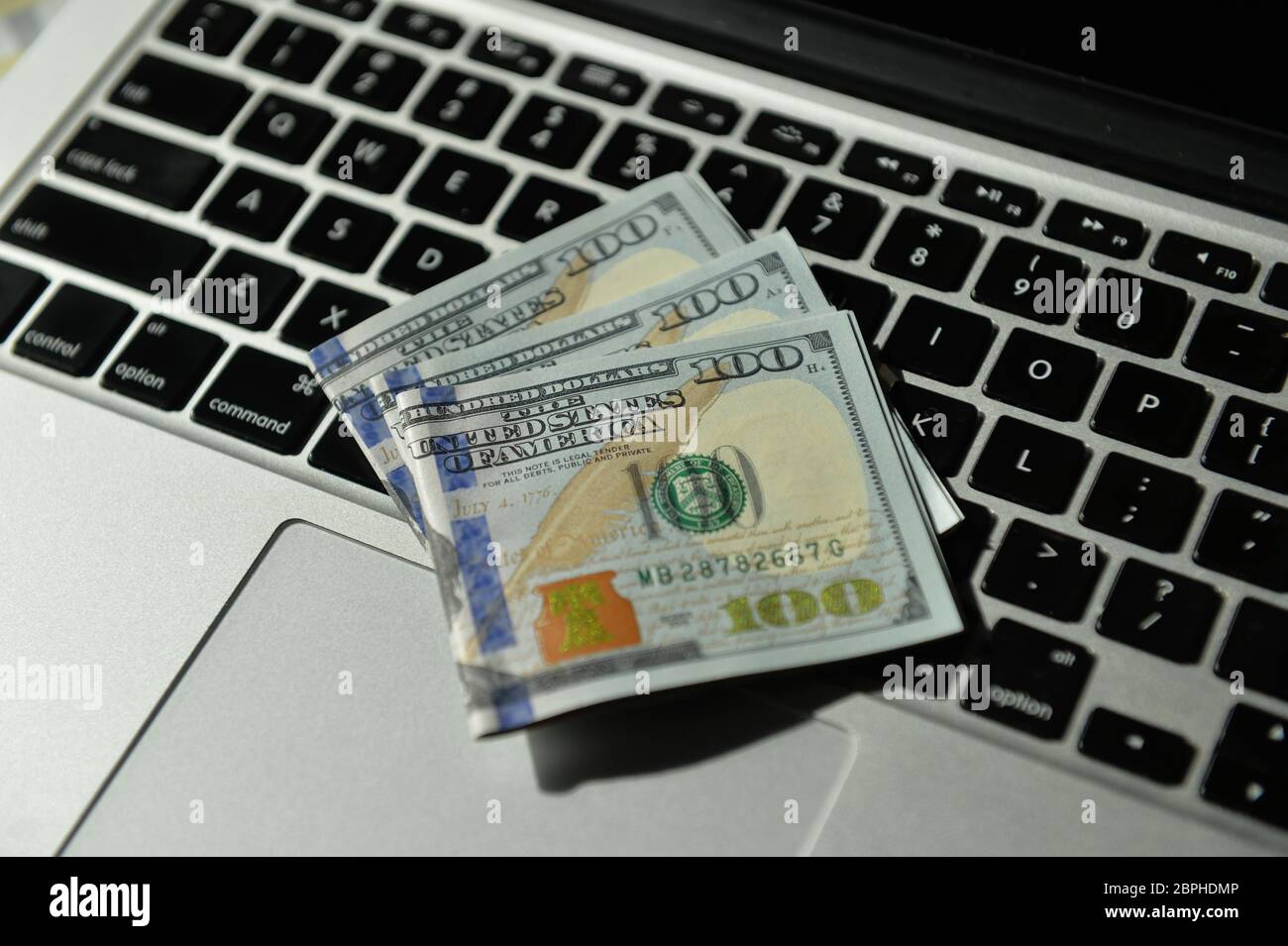 Cedulas de 100 Dollares sobre teclado de notebook Stock Photo