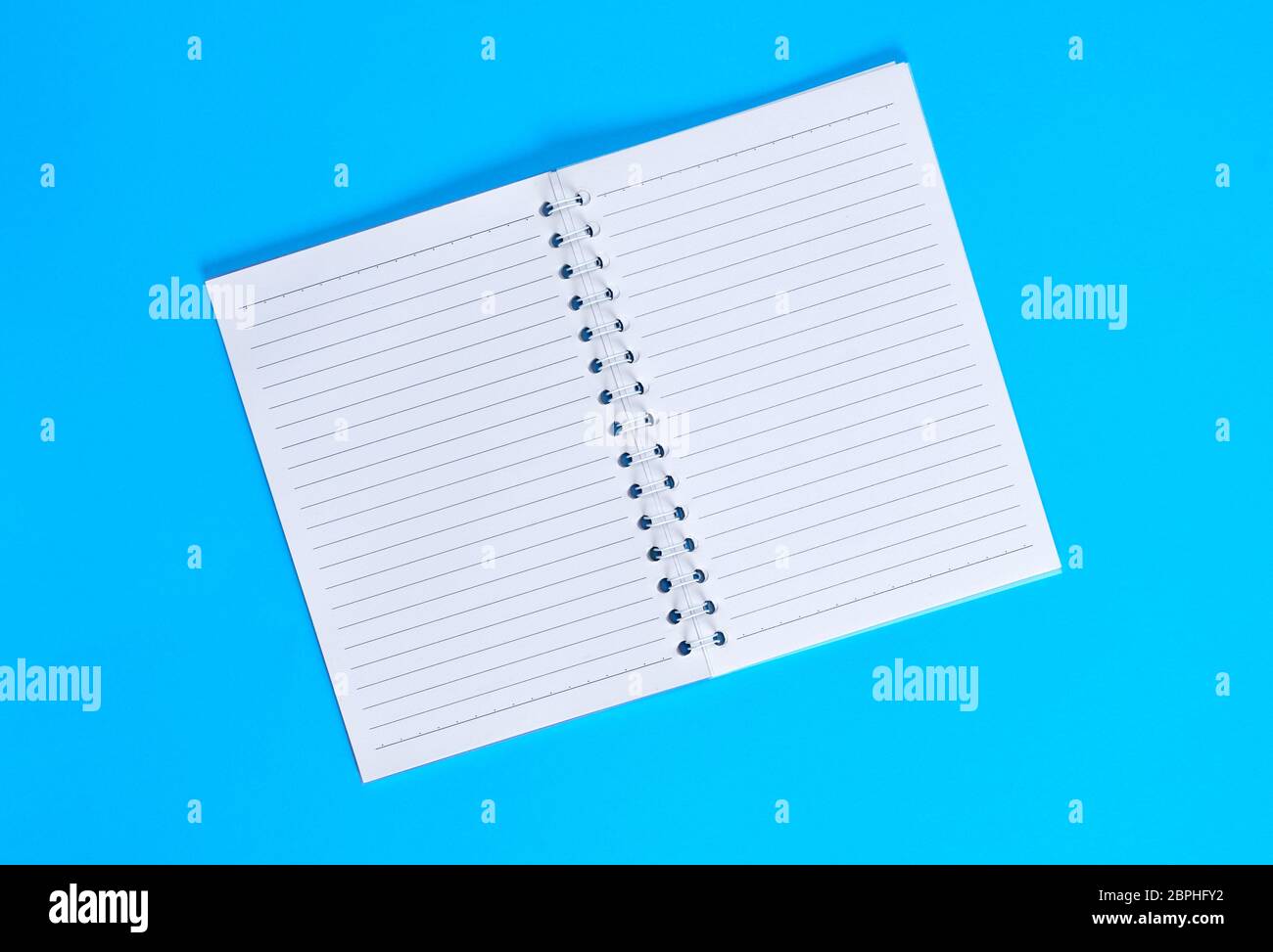 notebook with empty white sheets in line , blue background, top view Stock Photo