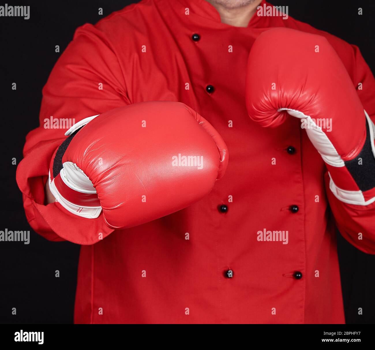 chef in red uniform and leather boxing gloves standing in a rack, black ...