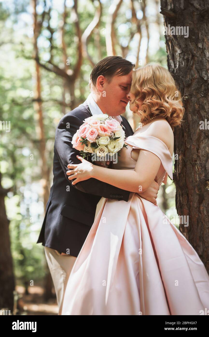 bride and groom kiss on the background of trees and forest Stock Photo ...