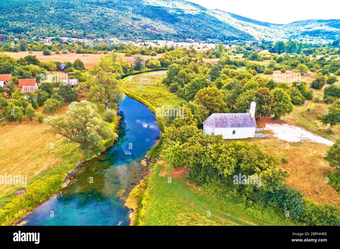 Stone church by Gacka river aerial view, Lika region of Croatia Stock Photo