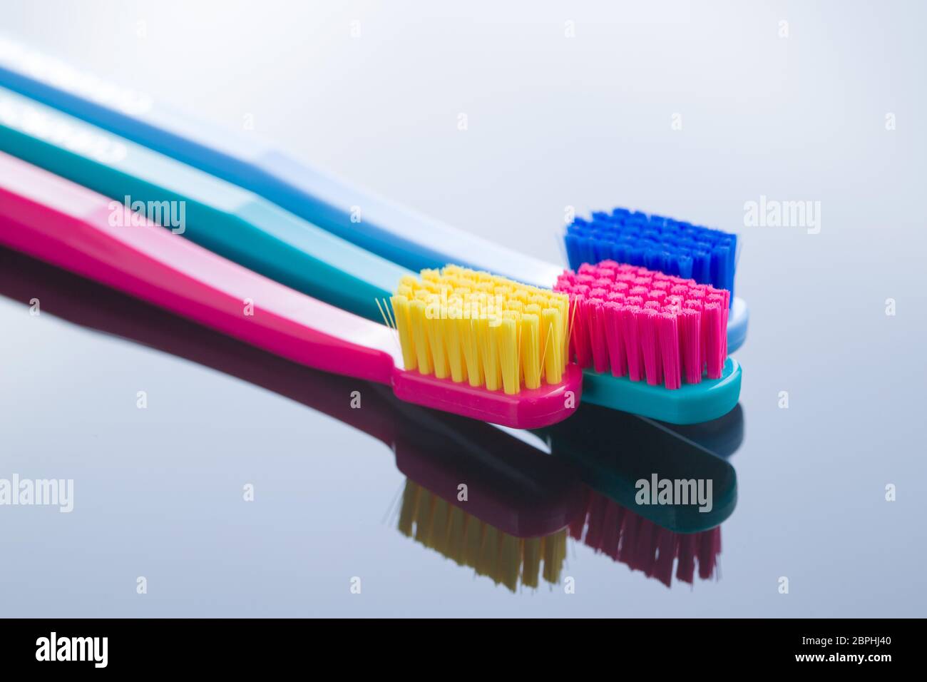 Colorful toothbrushes on mirror background Stock Photo - Alamy