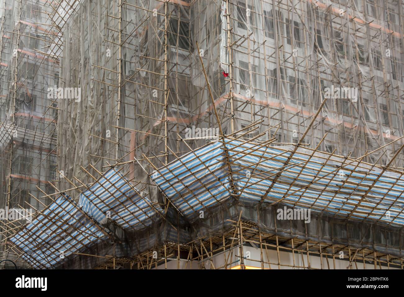 A high rise building being built in Hong Kong, utilizing bamboo scaffolding Stock Photo