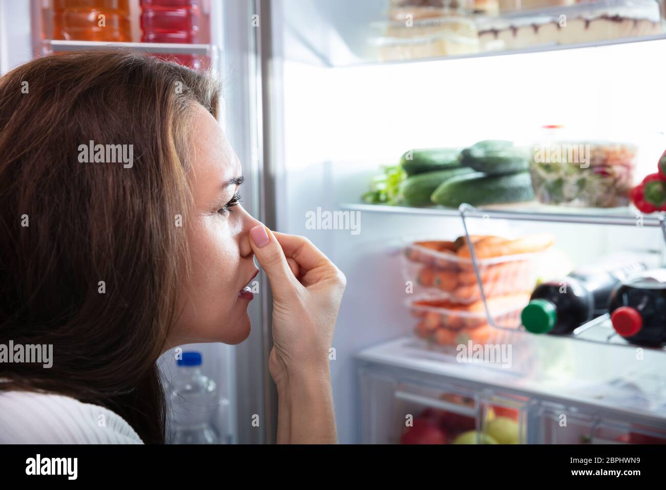 Side View Of Young Woman Recognizing Bad Smell Coming From The