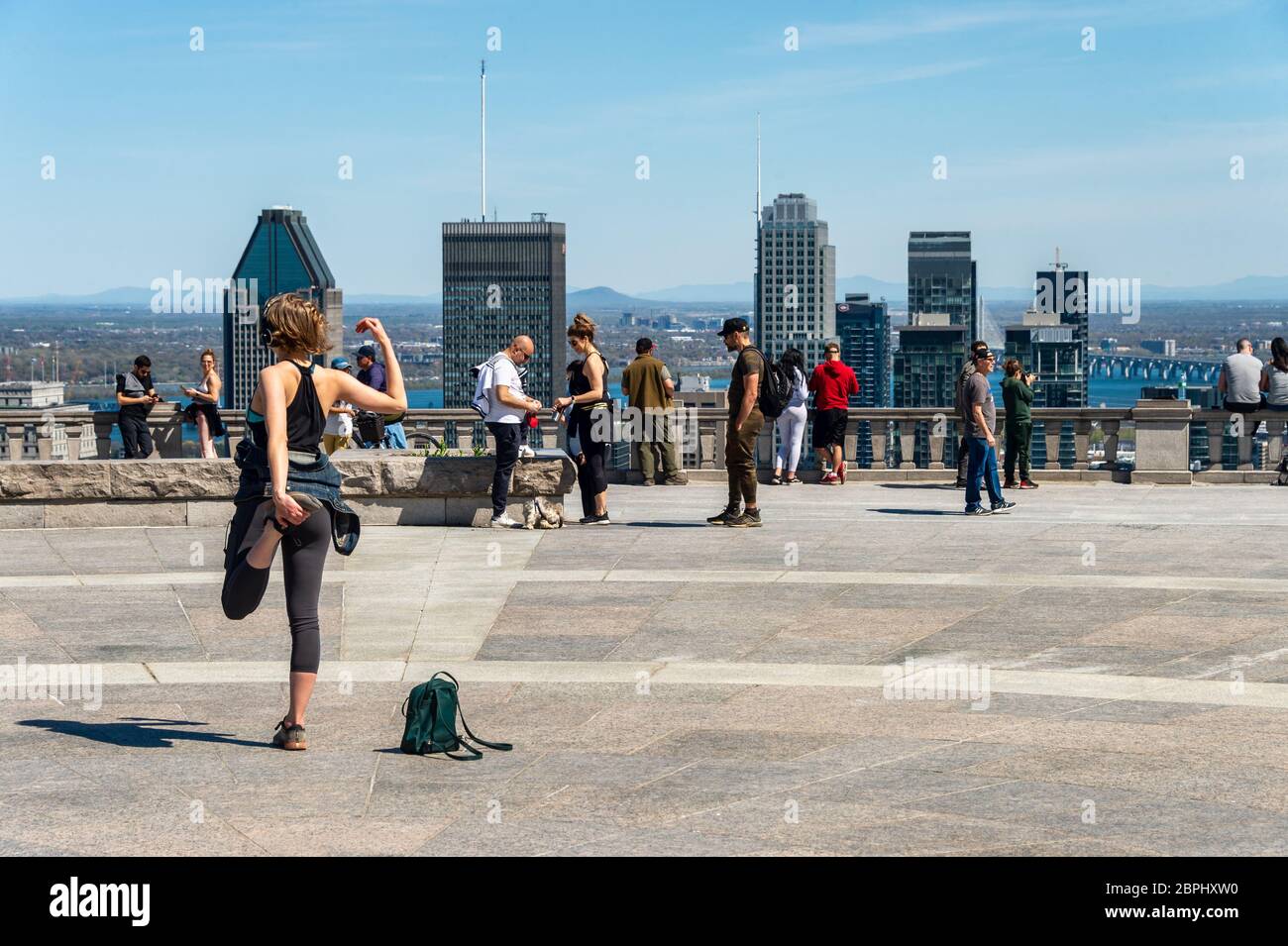 Montreal, CA - 18 May 2020: Young woman streching and working out outdoors at the top of Mount Royal during Covid-19 pandemic Stock Photo