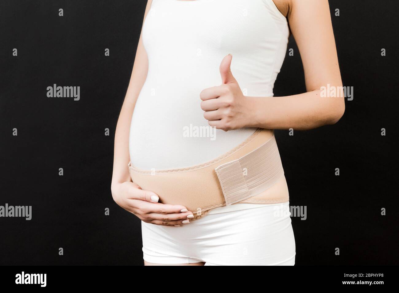 Premium Photo  Close up of pregnant woman in underwear dressed in  orthopedic corset on blue surface with copy space. orthopedic abdominal  support belt concept.