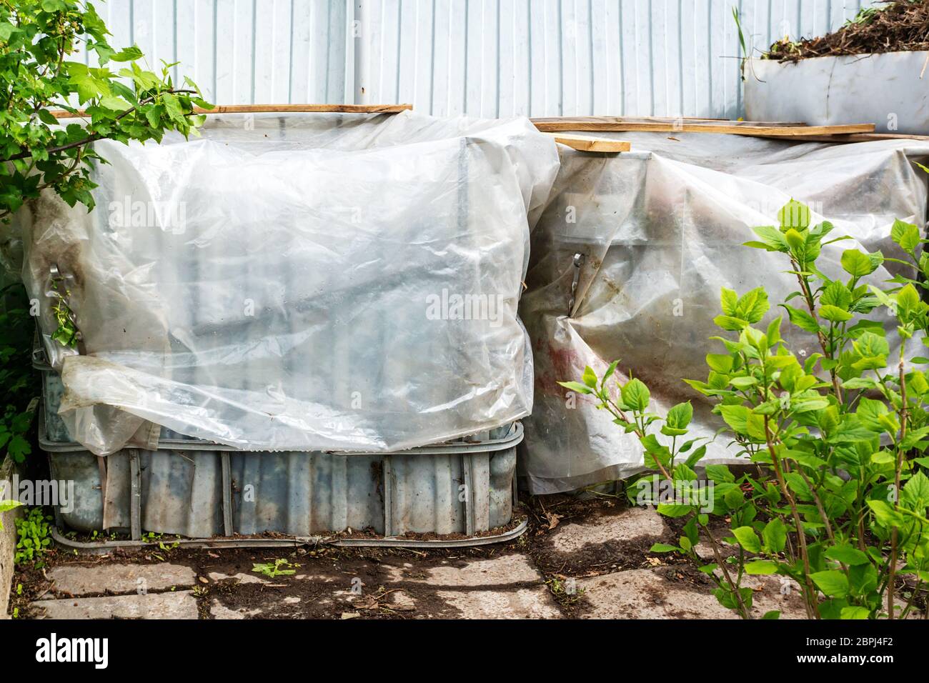 Plastic containers are reused for composting waste in the garden. fresh