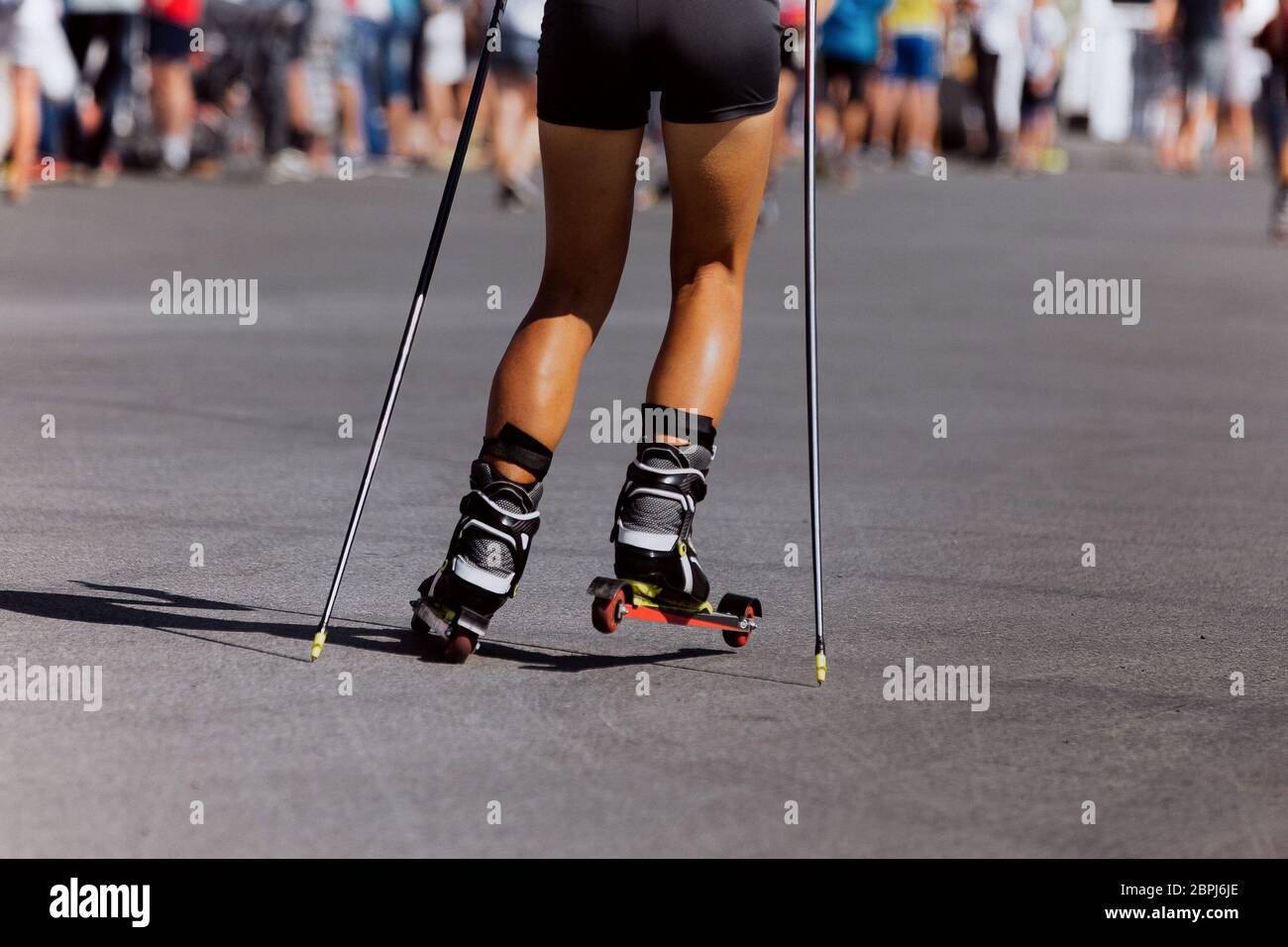 back girl skier roller skiing race on asphalt Stock Photo