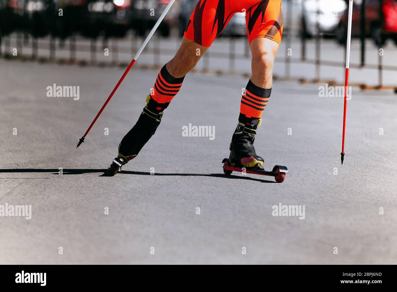 legs of skier athlete on roller ski and poles Stock Photo