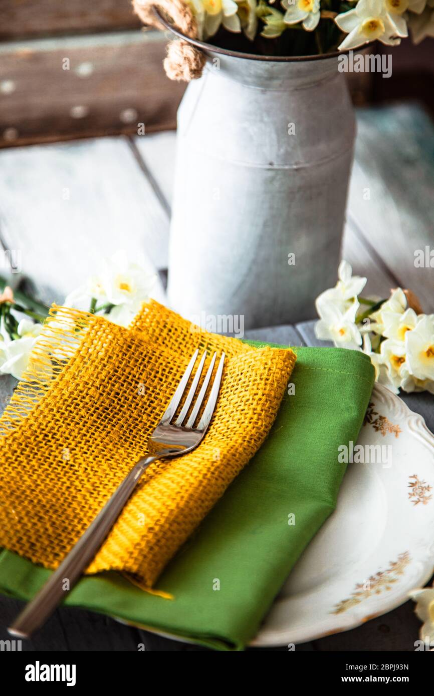 Spring table setting. Narcissus flower. Fork on Easter table. Holiday table setting Stock Photo