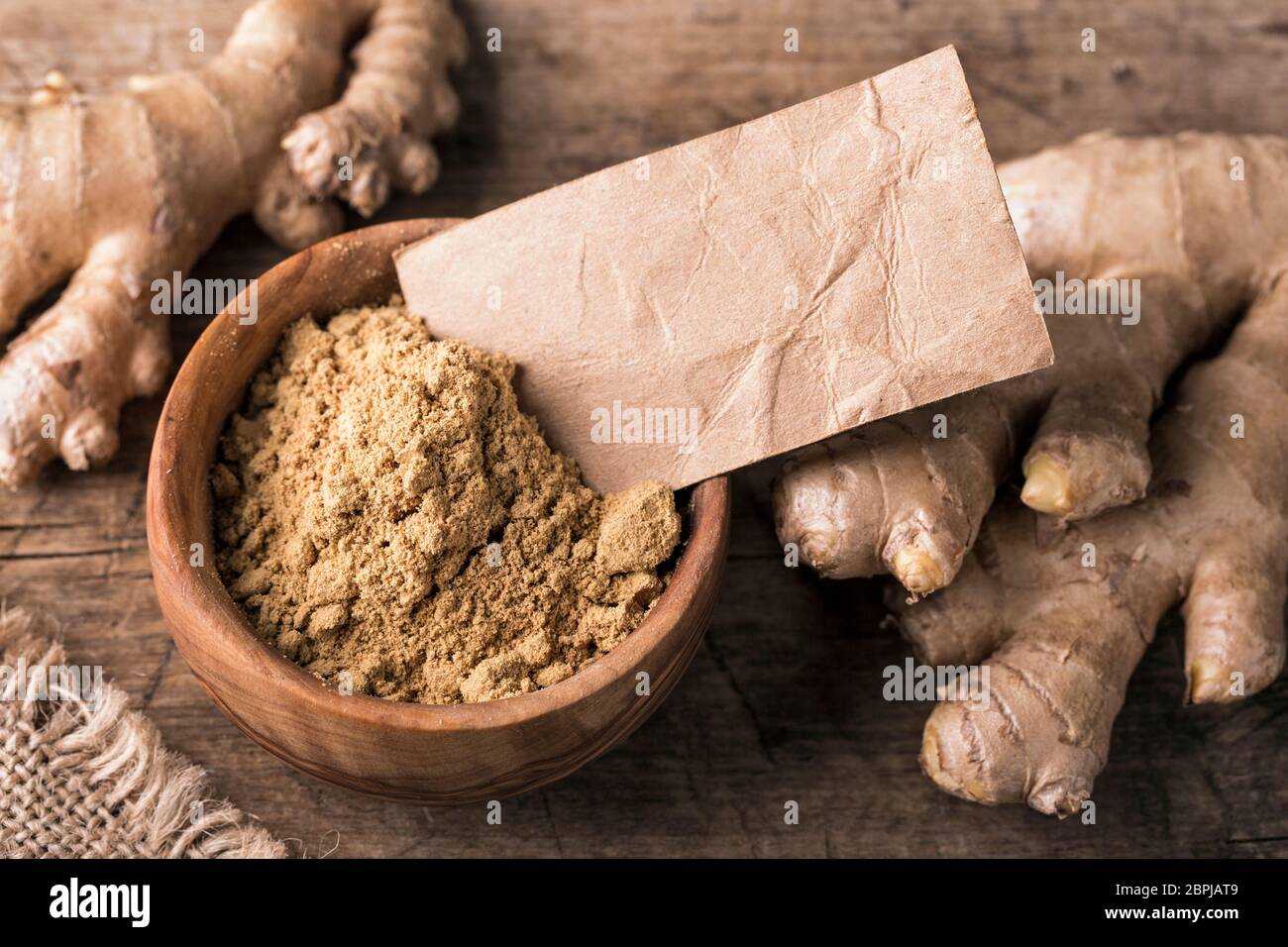 Ginger powder and fresh roots Stock Photo
