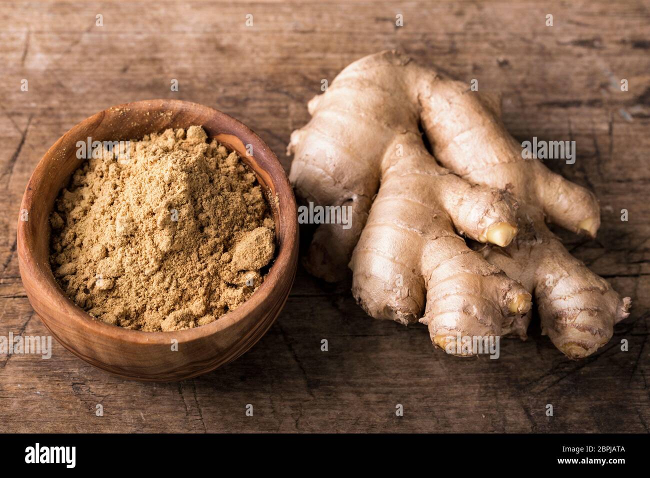 Ginger powder and fresh roots Stock Photo