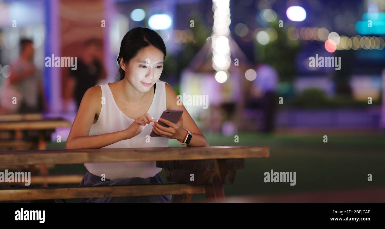 Woman use of mobile phone at outdoor cafe Stock Photo