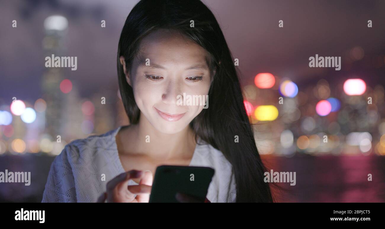 Woman use of mobile phone for online in Hong Kong at night Stock Photo ...