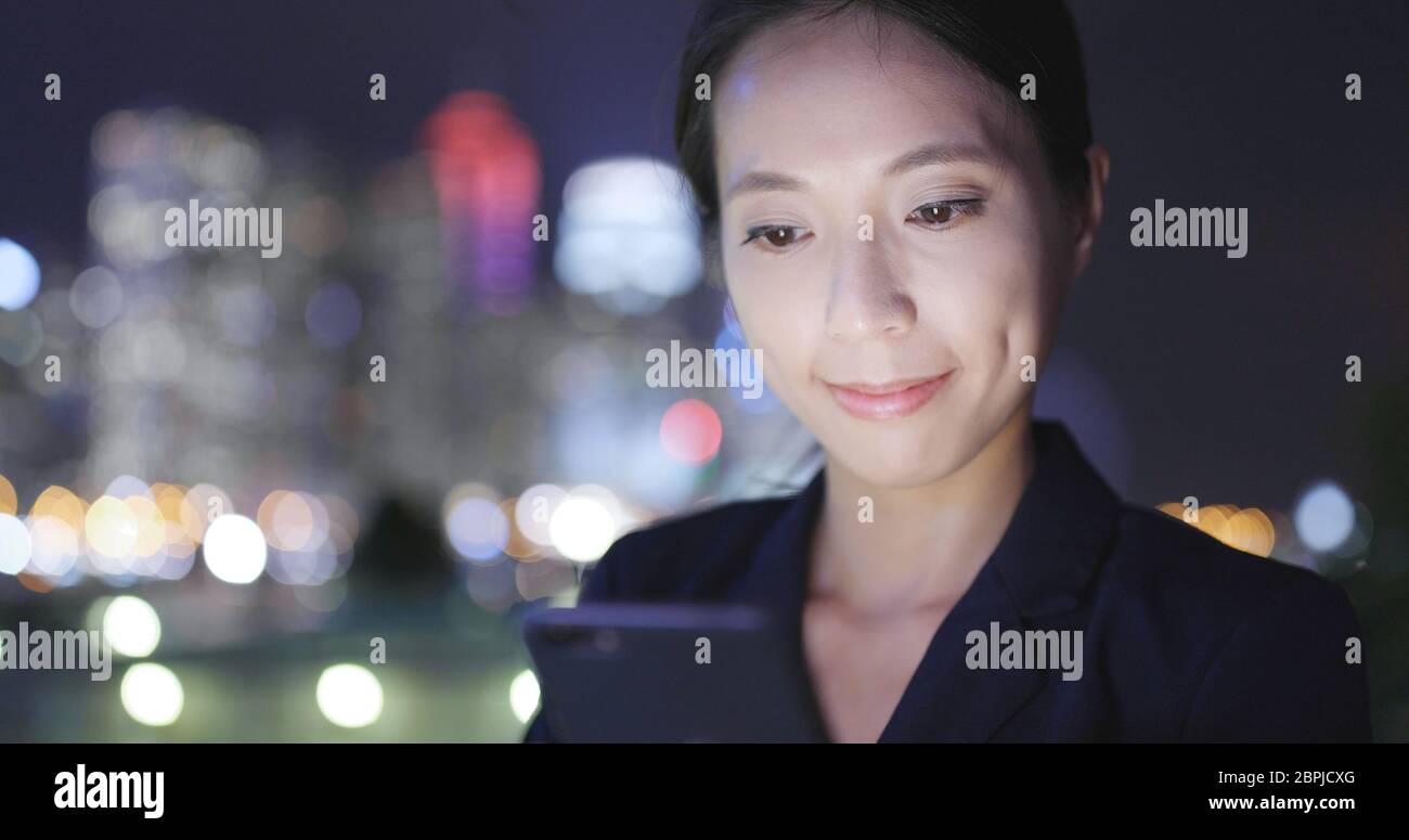 Business woman use of cellphone in Hong Kong city at night Stock Photo ...