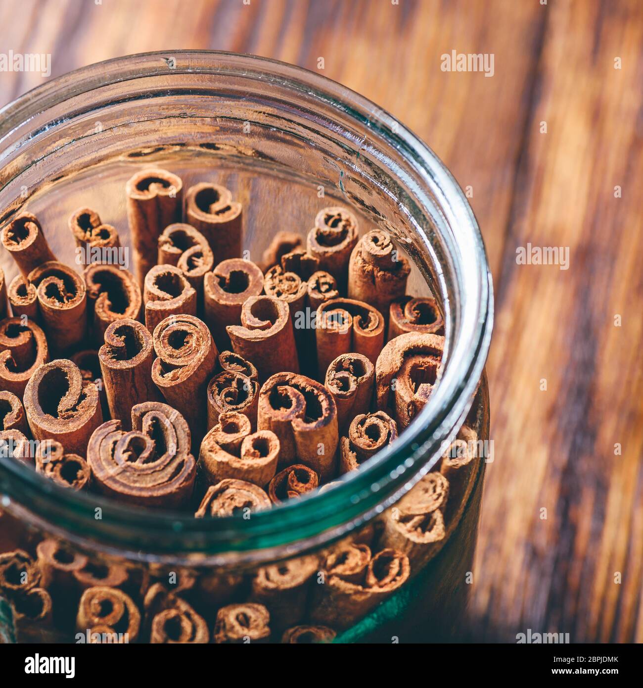 Cinnamon Sticks in Jar. View through the Bottleneck. Stock Photo