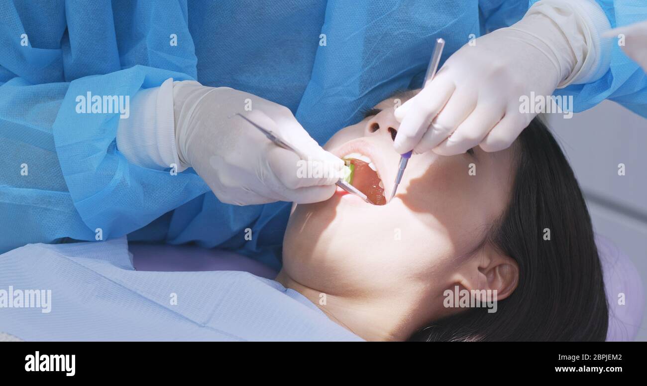 Woman undergo professional tooth whitening and ultrasound cleaning at dental clinic Stock Photo