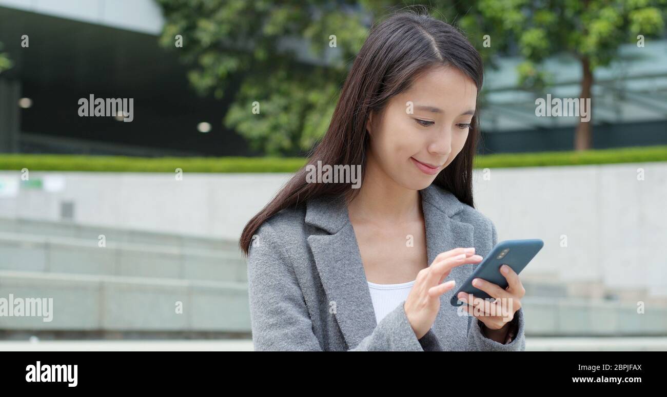 Business woman use of mobile phone in Hong Kong city Stock Photo - Alamy
