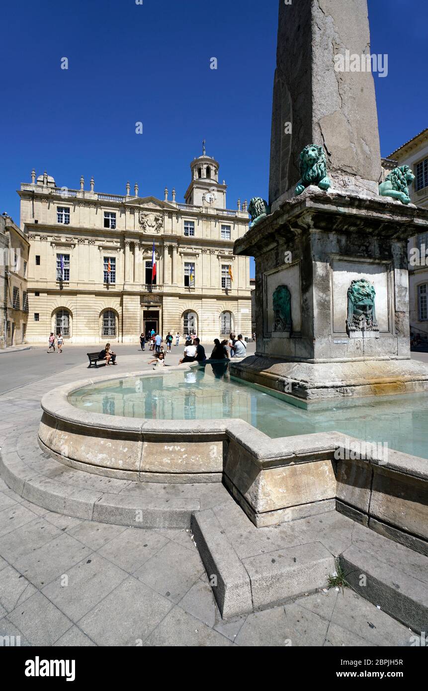 The fountain of 4th century Arles Obelisk in Place de la Republique with Town Hall (Hotel de Ville) in the background.Arles.Bouches-du-Rhone. Alpes-Cote d'Azur. France Stock Photo