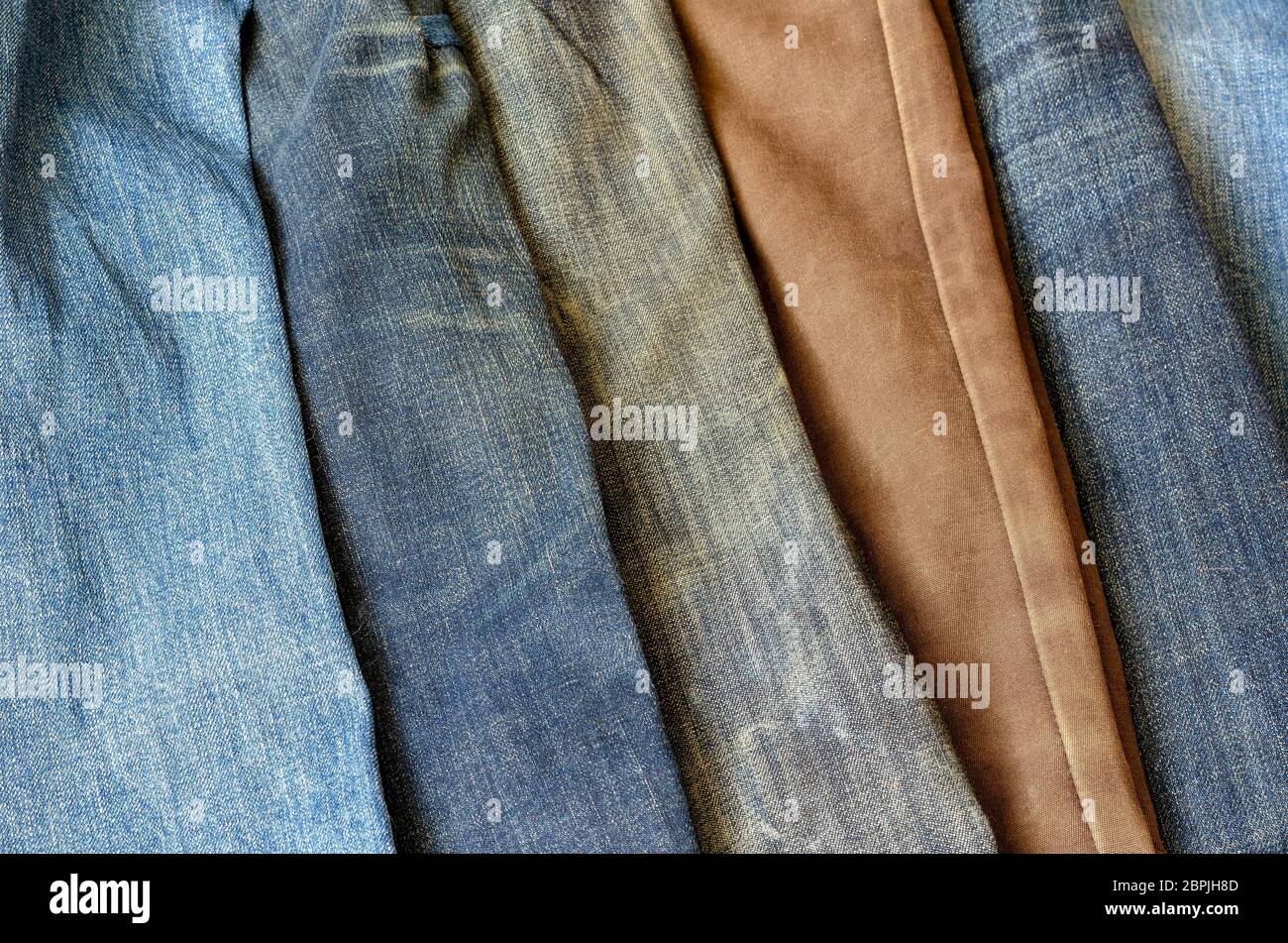 Multi-colored jeans on a store counter. Demonstration of various color  shades of denim trousers. Modern casual wear. Top view at an angle.  Selective f Stock Photo - Alamy