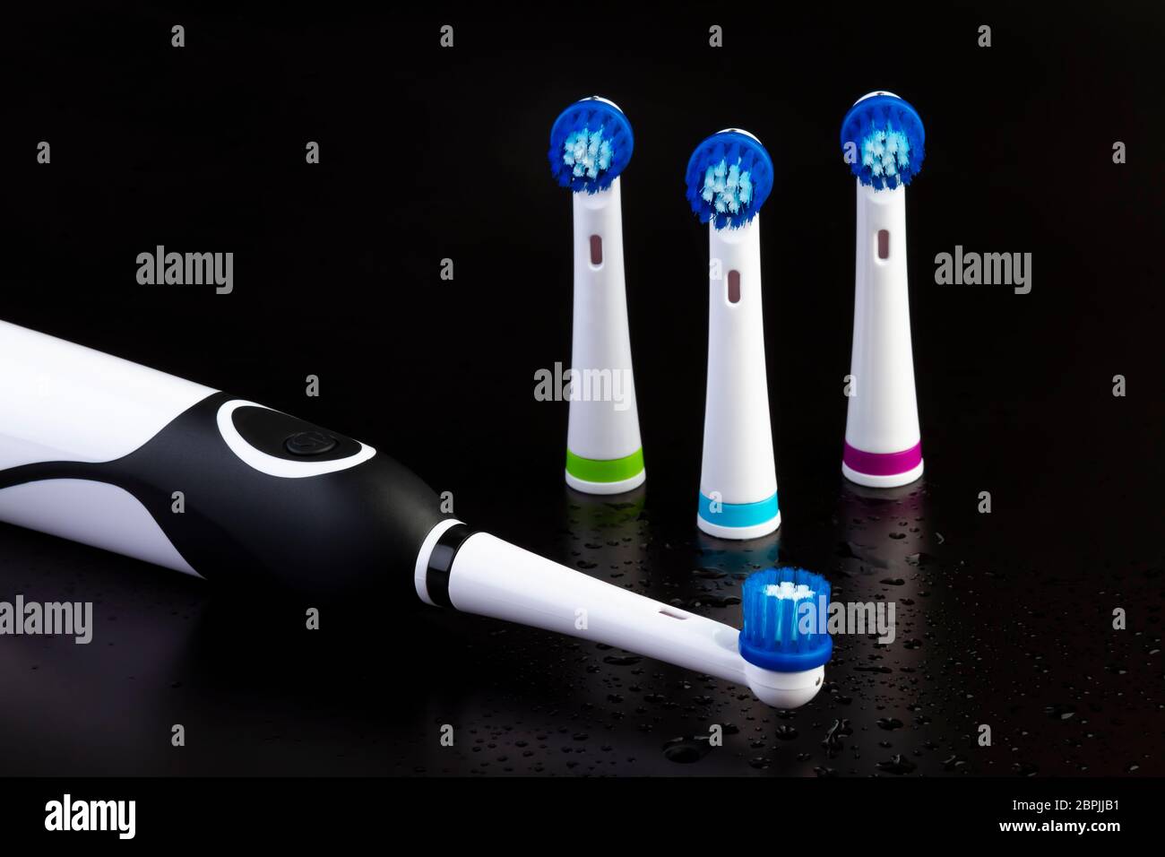 Electric rechargeable toothbrush with three toothbrush heads on black ...
