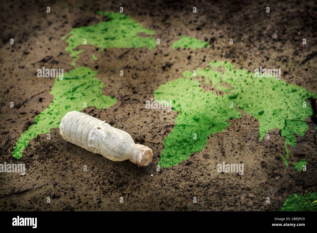 One Waste is already too much for our Earth Concept, World Map and an Old Plastic Bottle on Earth Stock Photo