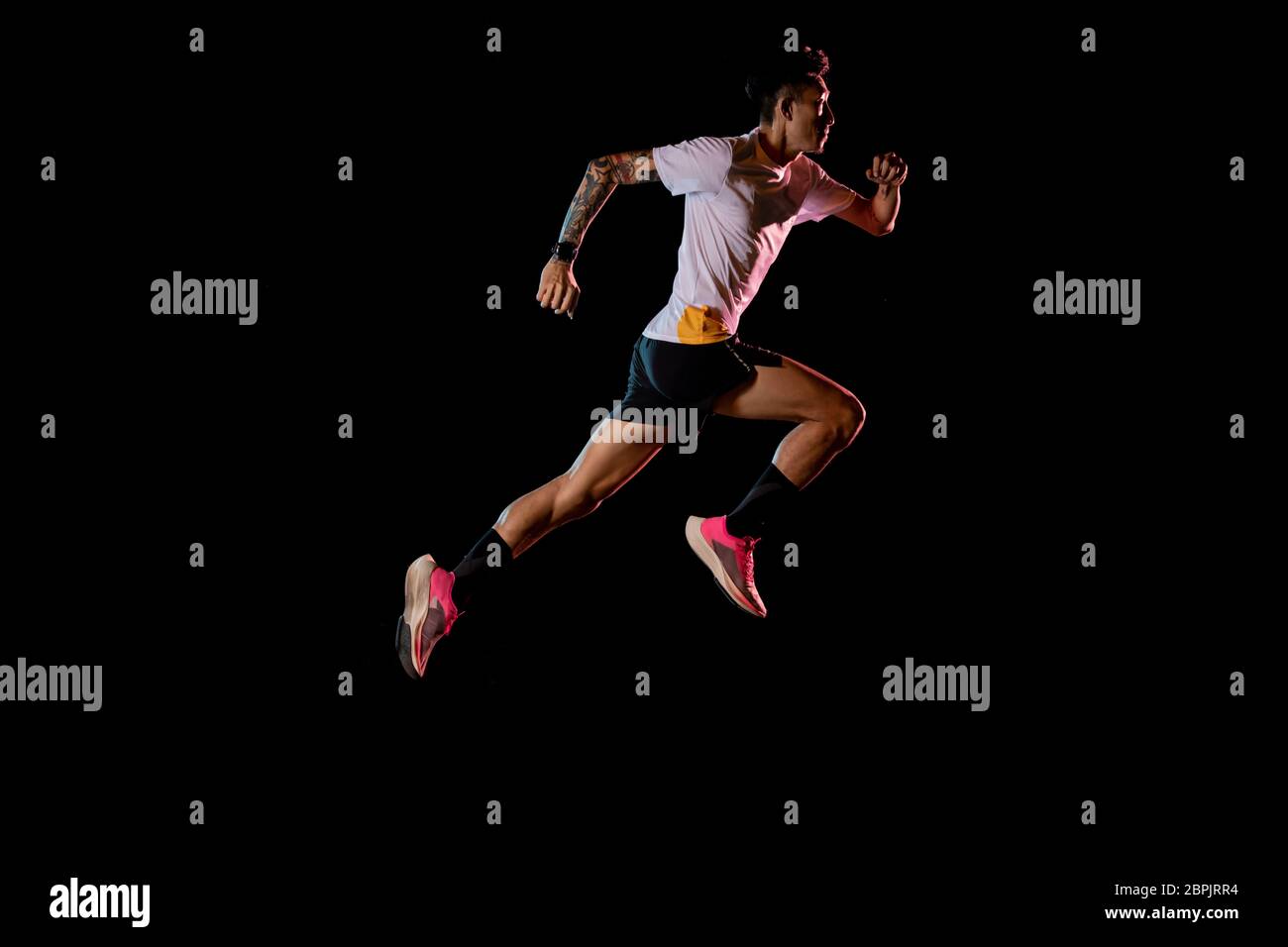 Asian man young sprinter runner running in studio on black background Stock Photo