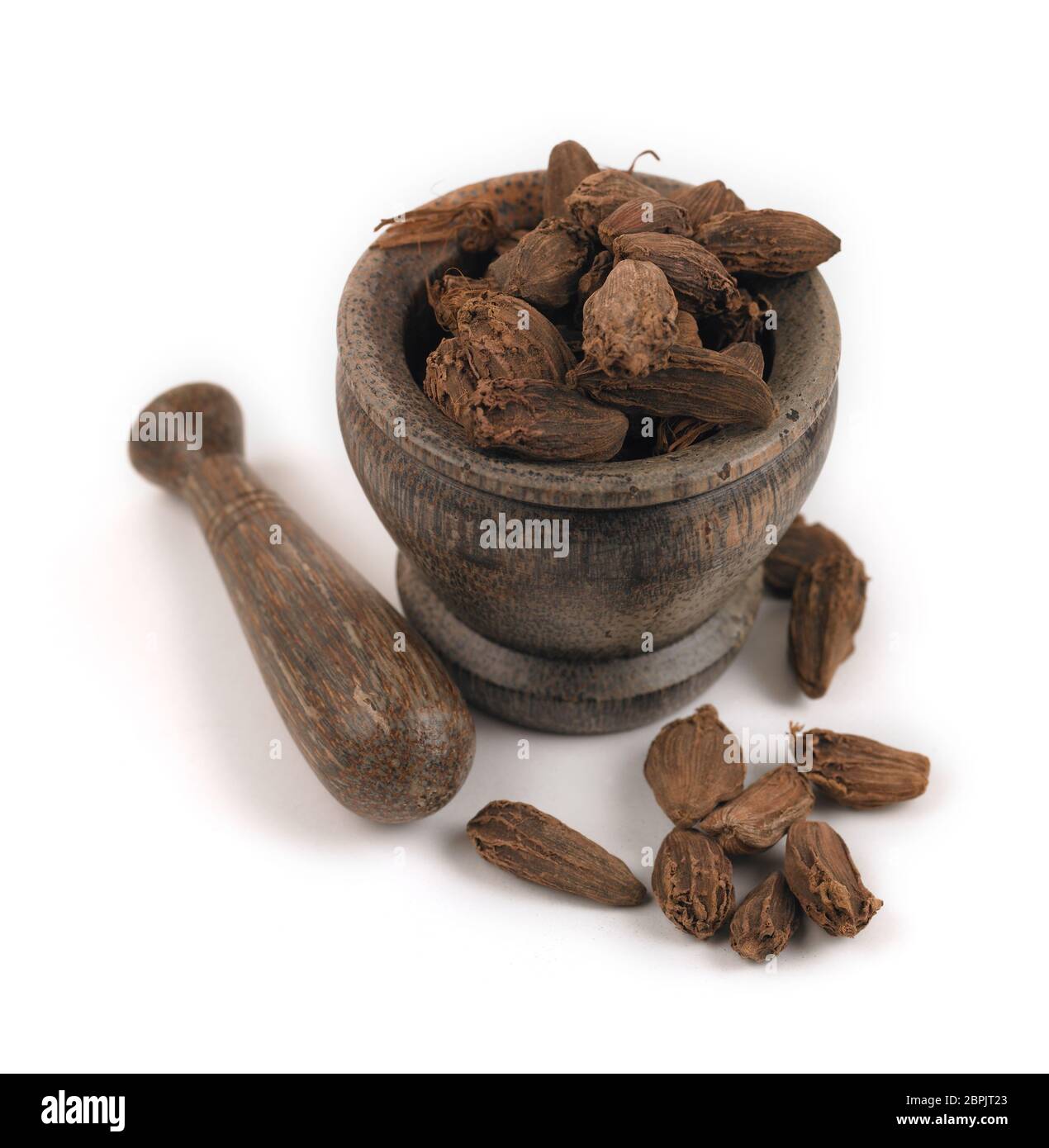 Whole black cardamom pods with wooden mortar and pestle on a white