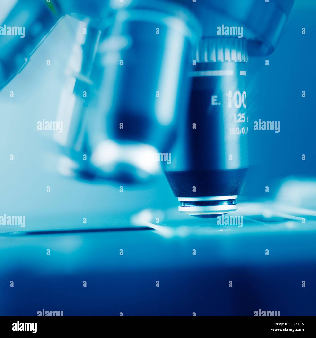 Lenses on the turret of a research microscope with glass slide on stage