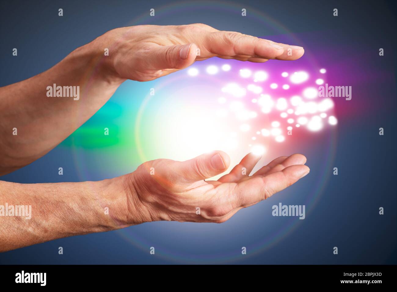 Close-up Of A Person's Hand Holding Light Against Shiny Background Stock Photo