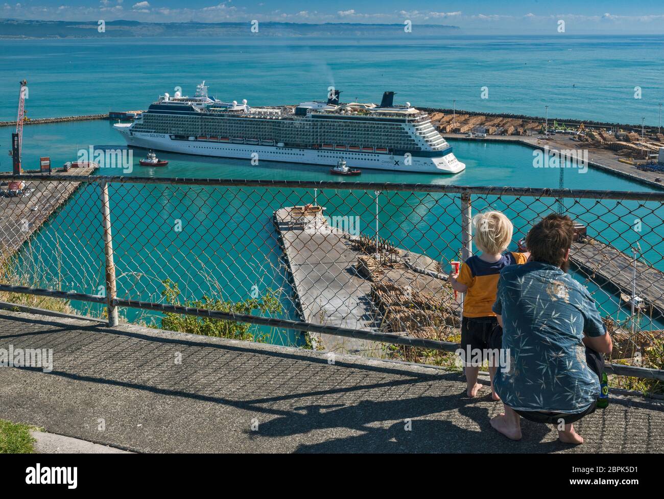 Father and his son watching Celebrity Solstice cruise ship entering Port of Napier, Hawke's Bay Region, North Island, New Zealand Stock Photo