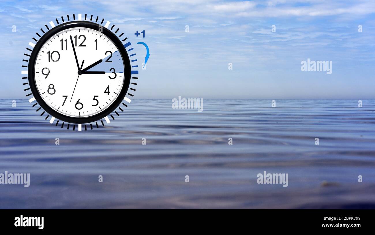 Daylight Saving Time (DST) Wall Clock on sea landscape. Turn time forward. Abstract photo of changing time at spring. Stock Photo
